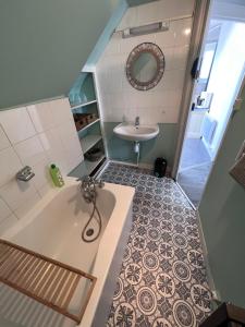 ein Badezimmer mit einer Badewanne und einem Waschbecken in der Unterkunft L'ancre Bleue in Dieppe