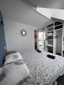 ein Schlafzimmer mit einem großen Bett und einem Spiegel in der Unterkunft L'ancre Bleue in Dieppe