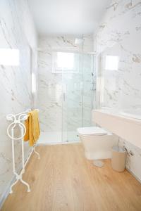 La salle de bains est pourvue d'une douche en verre et de toilettes. dans l'établissement Céntrico apartamento en Vilanova de Arousa, à Villanueva de Arosa
