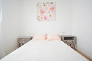 - une chambre avec un lit blanc avec deux tables et un tableau dans l'établissement Céntrico apartamento en Vilanova de Arousa, à Villanueva de Arosa