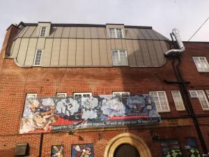 un edificio con un mural en el costado en The Mad Hatter, en Oxford