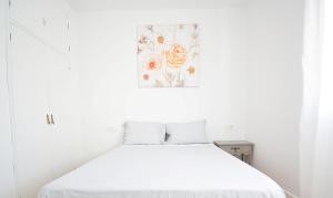 a white bed in a white room with a picture on the wall at Céntrico apartamento en Vilanova de Arousa in Villanueva de Arosa +7 photos