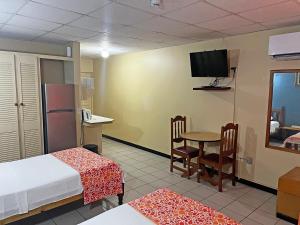 a room with two beds and a table and a tv at Sundeck Suites in Boissiere Village