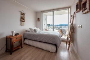 - une chambre avec un lit et une grande fenêtre dans l'établissement Exquisito Depto con Vista al Lago y Tinaja, à Puerto Varas