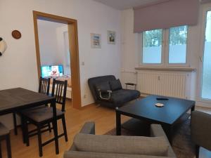 een woonkamer met een tafel en een stoel bij FeWo s Runde Wiese LL in Greifswald