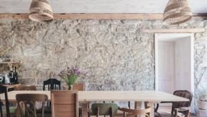 comedor con mesas y sillas y pared de piedra en Zapomnienie, en Nowa Ruda