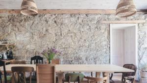 a dining room with tables and chairs and a stone wall at Zapomnienie in Nowa Ruda