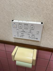 a box on a wall above a toilet paper dispenser at 民宿ふじ苑 