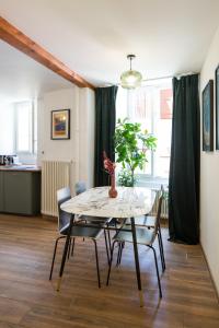 a dining room table with chairs and a vase with a plant at Marché 28 Guesthouse in Montreux