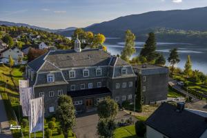 an aerial view of a large house with a lake at Brattrein Hotell - Unike Hoteller in Notodden