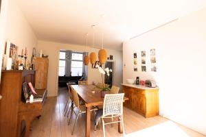 eine Küche und ein Esszimmer mit einem Holztisch und Stühlen in der Unterkunft B&B Brouwersvaart in Haarlem