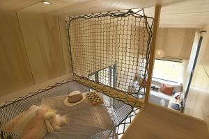 una jaula con un animal de peluche y un sombrero en una habitación en La tiny house de la Blandinière en Vertou