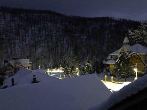 a house covered in snow at night at Casa Ana in Moneasa +6 photos