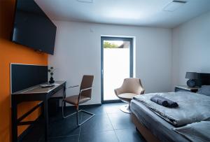 um quarto com uma cama, uma secretária e cadeiras em Blauer Stein Apartments WH2 em Pulheim