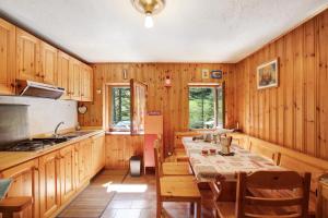 a kitchen with wooden walls and a table with chairs at Lo Peiglo Valgrisenche in Valgrisenche