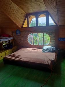 ein Schlafzimmer mit einem Bett in einem Zimmer mit Fenstern in der Unterkunft El SOL al ALVA in Duitama
