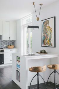 a kitchen with a white counter and two stools at Little Venice 3 bed with Private Terrace in London