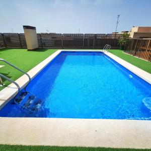 una gran piscina con agua azul en un patio en Apartamento con Aire Acondicionado, Piscina, Wifi y Smart TV - by Aloha Palma en Águilas