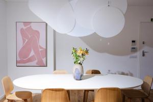 uma mesa branca com cadeiras e um vaso com flores em Design-Apartment Olhão by Sisters of Paradise em Olhão