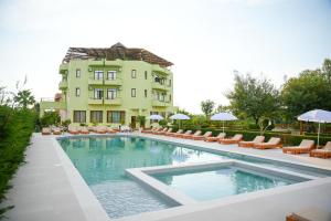 a swimming pool in front of a building at PARADISE Laguna Vain in Lezhë