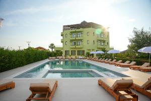 a hotel with a swimming pool and chairs and a building at PARADISE Laguna Vain in Lezhë
