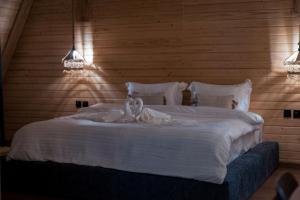Un dormitorio con una cama blanca con dos cisnes. en Terhabb Cottages, en Abha