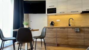 une cuisine avec un comptoir avec des chaises et un évier dans l'établissement Rising Sun 3 by Housine,pl, à Zator 17 autres photos