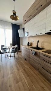 - une cuisine avec des placards en bois et une table avec un évier dans l'établissement Rising Sun 3 by Housine,pl, à Zator