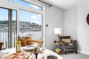 a dining room with a table with a pizza on it at Harbourside 3 - Luxury Riverside Apartment in Dartmouth