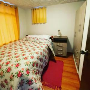 a bedroom with a bed with a floral comforter at Mi Pueblito Lodge in Huancayo
