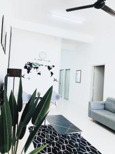 sala de estar con sofá azul y planta en D' Splash Garden Homestay, en Baling