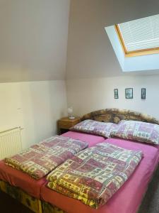 - une chambre avec un grand lit et des draps violets dans l'établissement Pokoje s vlastní koupelnou a WC, à Doksy