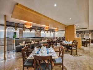 un ristorante con tavoli e sedie e un bar di Fortune Inn Heritage Walk Amritsar ad Amritsar