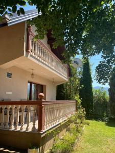 a house with a wooden balcony on the side of it at Holiday Home Zelena Oaza in Sarajevo