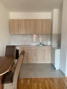 a kitchen with wooden cabinets and a wooden table at Stan na dan Foca in Foča