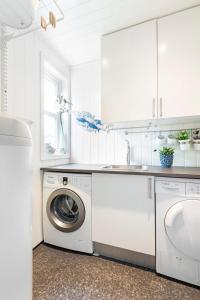 een witte keuken met een wasmachine en een wastafel bij Atlantic Panorama in Vevang