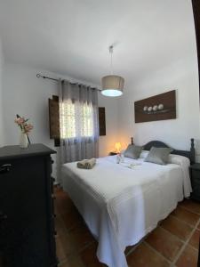- une chambre avec un lit blanc et une fenêtre dans l'établissement Cortijo Peña Blanca, à Grenade