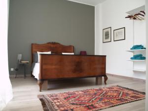 a bedroom with a wooden bed and a rug at B&B Casa Trucchi in Ventimiglia