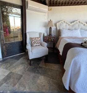 a bedroom with a bed and a chair and a window at Casa Grande Luxury Boutique Hotel in San Miguel de Allende