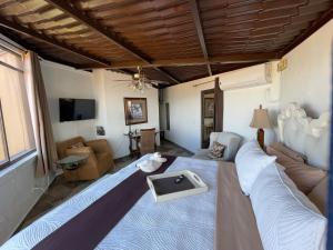 a bedroom with a large bed and a living room at Casa Grande Luxury Boutique Hotel in San Miguel de Allende