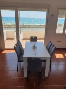 una mesa y sillas blancas con vistas al océano en Apartamentos La Calilla Cabo de Gata, en Cabo de Gata