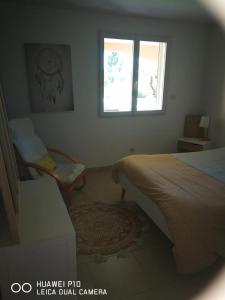 Schlafzimmer mit einem Bett, einem Fenster und einem Teppich in der Unterkunft Logement spacieux agréable in Saint-Privat