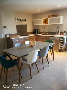 eine Küche mit einem Tisch und Stühlen in der Unterkunft Logement spacieux agréable in Saint-Privat