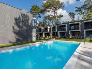 a large blue swimming pool in front of a building at Terraced houses, outdoor pool, Pobierowo in Pobierowo