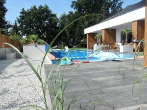 a swimming pool with a slide in front of a house at House with swimming pool in Swinoujscie for 16 people in Świnoujście
