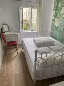 1 dormitorio con cama, escritorio y ventana en Ciel de Paris, en París