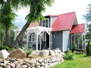 a house with a red roof and a yard at Holiday Home near Lake Mausz with Sauna in Kłodno