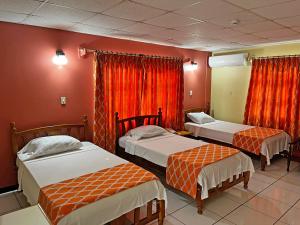 a room with three beds and red walls at Sundeck Suites in Boissiere Village