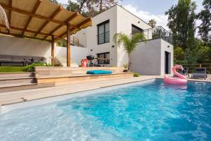 a swimming pool with a pink flamingo in front of a house at Villa modern Super-Cannes heated Pool, Parking, CLIM, 7 min to Cannes Beach in Vallauris
