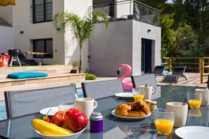 a table with a bowl of fruit and juice on it at Villa modern Super-Cannes heated Pool, Parking, CLIM, 7 min to Cannes Beach in Vallauris